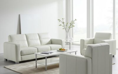 Modern white leather sofa and armchairs in a bright living room setting, emphasizing cleanliness and comfort, relevant to upholstery cleaning services offered by Steam Plus.